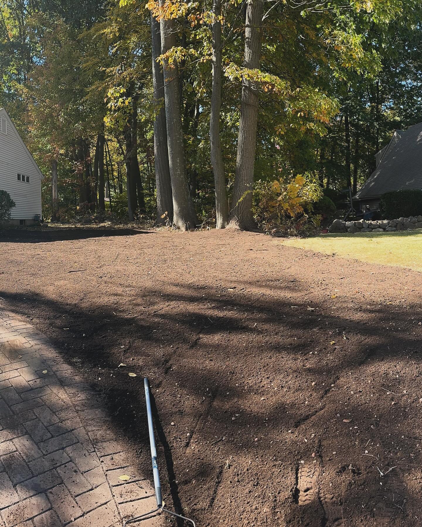 Cleared and graded residential lot prepared for landscaping, with visible rake and smooth soil surface – USA Tree Services project in Connecticut