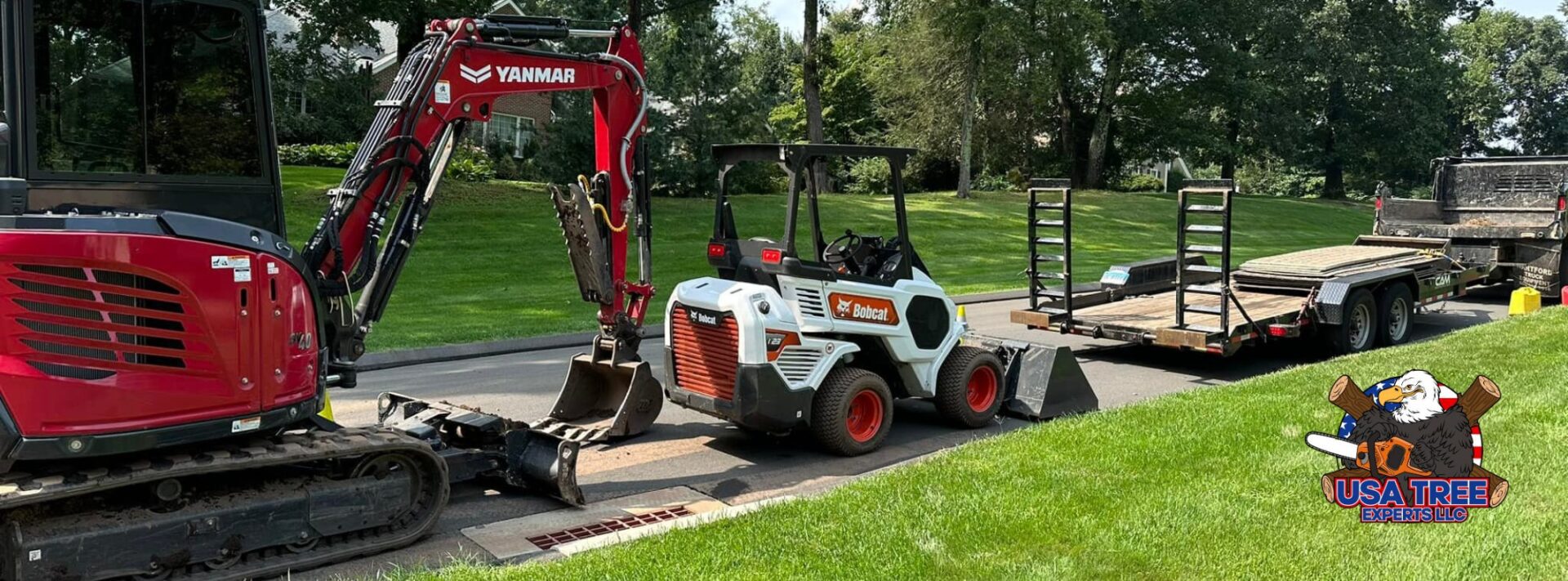 USA Tree Experts equipment lineup featuring Yanmar excavator, Bobcat loader, and trailer ready for land clearing and tree removal services in Connecticut